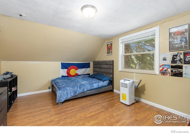 144 Placer Ave, Longmont, CO 80504 - bedroom featuring vaulted ceiling and wood finished floors