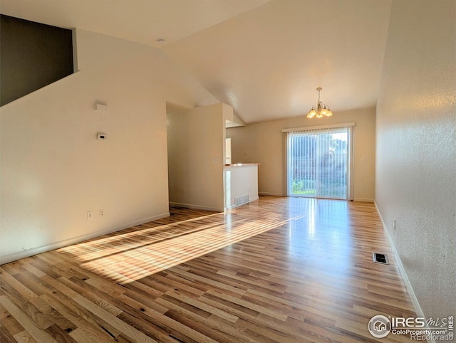 3705 Dove Ln, Evans, CO 80620 - unfurnished living room featuring a chandelier, wood finished floors, and vaulted ceiling