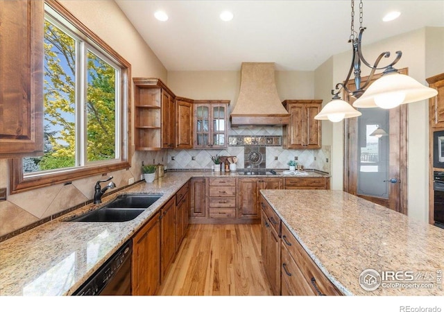 8276 Blackwood Dr, Windsor, CO 80550 - kitchen featuring premium range hood, black appliances, plenty of natural light, light stone countertops, and recessed lighting