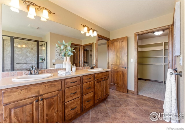 8276 Blackwood Dr, Windsor, CO 80550 - bathroom featuring double vanity, a shower stall, tile patterned floors, and a spacious closet