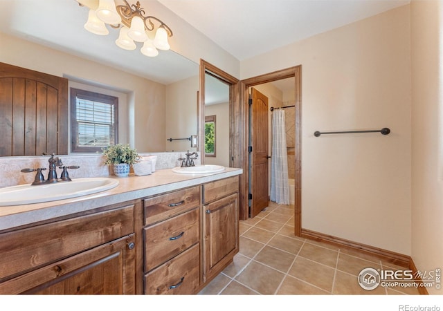 8276 Blackwood Dr, Windsor, CO 80550 - bathroom with double vanity, tile patterned floors, a chandelier, and healthy amount of natural light