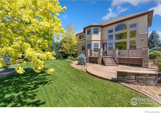 8276 Blackwood Dr, Windsor, CO 80550 - back of house featuring stucco siding, a deck, a yard, and a patio