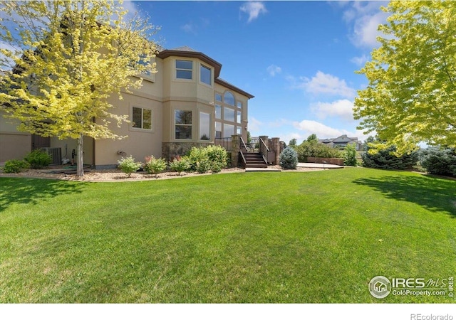 8276 Blackwood Dr, Windsor, CO 80550 - back of property featuring stucco siding and a lawn
