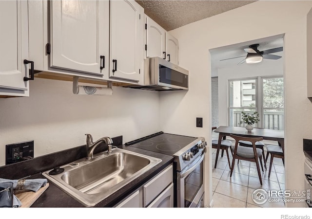 3030 Oneal Pkwy # 21R, Boulder, CO 80301 - kitchen featuring stainless steel appliances, white cabinetry, a ceiling fan, light tile patterned floors, and a textured ceiling
