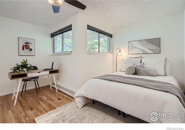 3030 Oneal Pkwy # 21R, Boulder, CO 80301 - bedroom with light wood-style floors, a textured ceiling, a baseboard heating unit, and ceiling fan