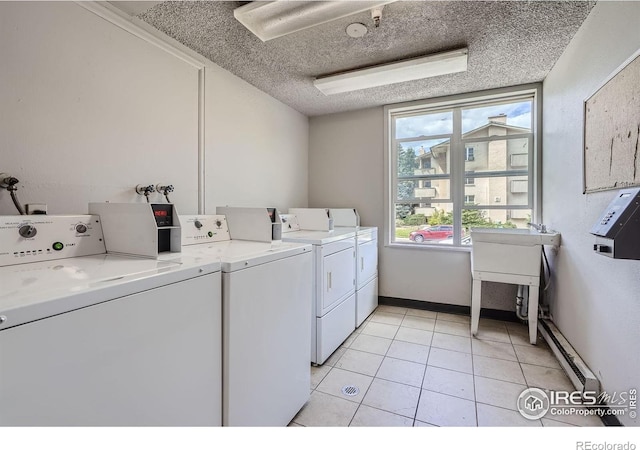 3030 Oneal Pkwy # 21R, Boulder, CO 80301 - shared laundry room featuring washer and clothes dryer, light tile patterned flooring, and a textured ceiling
