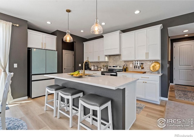 1228 104th Avenue Ct, Greeley, CO 80634 - kitchen with freestanding refrigerator, stainless steel electric range, tasteful backsplash, white cabinets, and recessed lighting