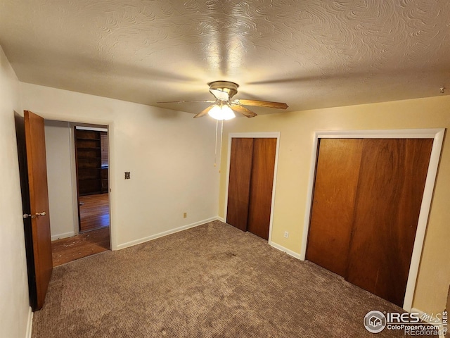 1107 Delmar St, Sterling, CO 80751 - unfurnished bedroom featuring multiple closets, carpet flooring, a ceiling fan, and a textured ceiling