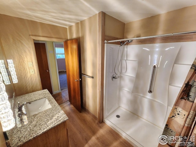 1107 Delmar St, Sterling, CO 80751 - bathroom with wood finished floors, a shower, and vanity