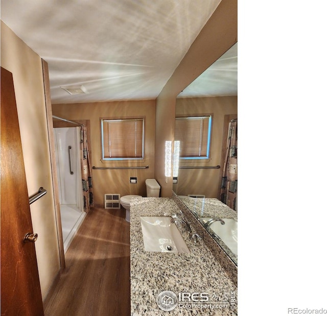 1107 Delmar St, Sterling, CO 80751 - full bathroom with wood finished floors, a stall shower, and vanity