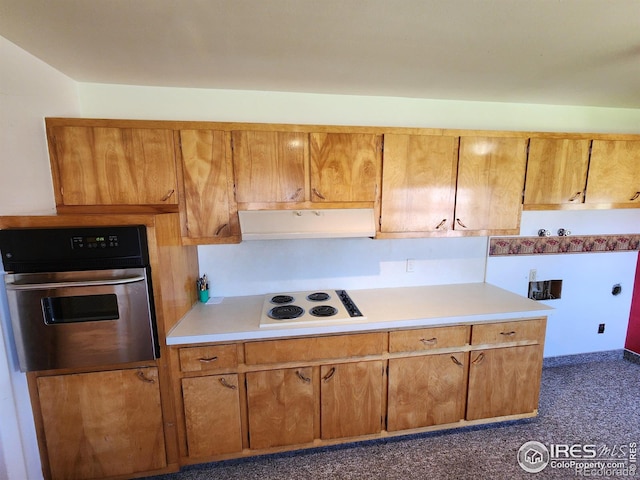 1107 Delmar St, Sterling, CO 80751 - kitchen featuring oven, white electric cooktop, under cabinet range hood, light countertops, and brown cabinets