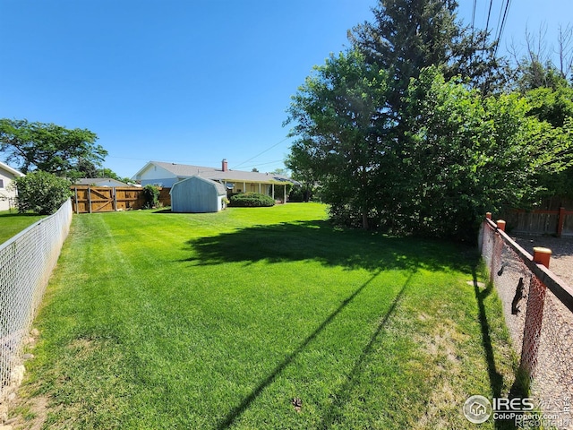 1107 Delmar St, Sterling, CO 80751 - fenced backyard featuring a storage unit