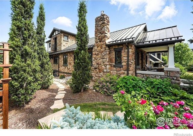 2958 6th St, Boulder, CO 80304 - back of house featuring a standing seam roof, stone siding, a metal roof, and a chimney