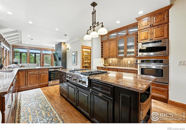 2958 6th St, Boulder, CO 80304 - kitchen featuring appliances with stainless steel finishes, light wood-style flooring, decorative backsplash, brown cabinets, and recessed lighting