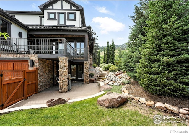 2958 6th St, Boulder, CO 80304 - back of house featuring a balcony, a patio, stucco siding, and stone siding