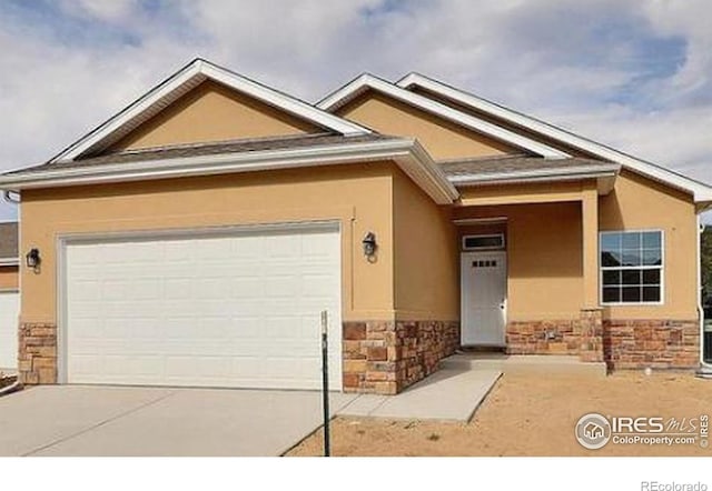 1230 Swainson Rd, Eaton, CO 80615 - view of front of home with stone siding, stucco siding, an attached garage, and driveway
