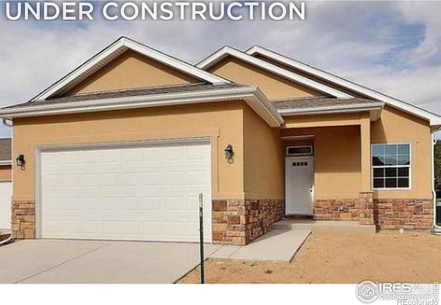 1230 Swainson Rd, Eaton, CO 80615 - view of front of home with stone siding, stucco siding, concrete driveway, and a garage
