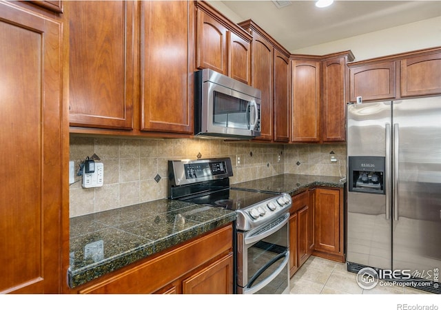 15233 W 65th Ave Unit C, Arvada, CO 80007 - kitchen with appliances with stainless steel finishes, light tile patterned floors, tasteful backsplash, and brown cabinets
