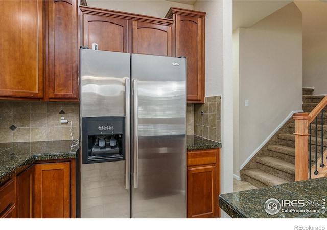 15233 W 65th Ave Unit C, Arvada, CO 80007 - kitchen with stainless steel fridge, decorative backsplash, brown cabinets, tile patterned flooring, and dark stone countertops