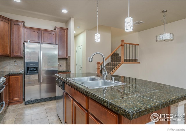 15233 W 65th Ave Unit C, Arvada, CO 80007 - kitchen with appliances with stainless steel finishes, tile counters, a center island with sink, decorative backsplash, and recessed lighting