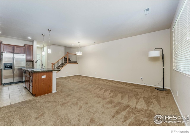 15233 W 65th Ave Unit C, Arvada, CO 80007 - kitchen with stainless steel refrigerator with ice dispenser, light carpet, decorative light fixtures, a center island with sink, and recessed lighting