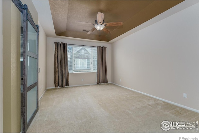 15233 W 65th Ave Unit C, Arvada, CO 80007 - empty room with a tray ceiling, carpet floors, a ceiling fan, a barn door, and a textured ceiling