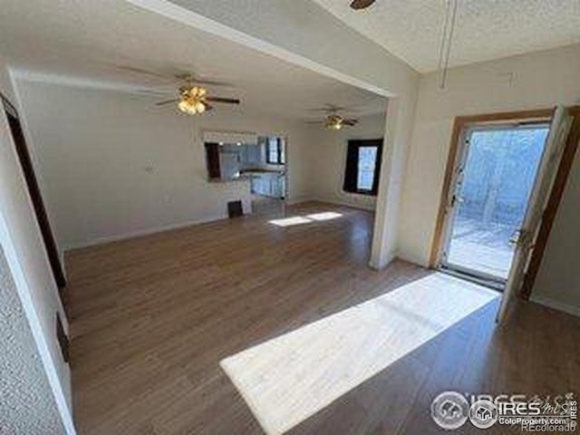 709 S 2nd Ave S, Sterling, CO 80751 - unfurnished living room with a ceiling fan, wood finished floors, and a textured ceiling