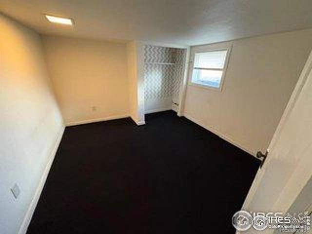 709 S 2nd Ave S, Sterling, CO 80751 - unfurnished room featuring dark carpet and baseboards