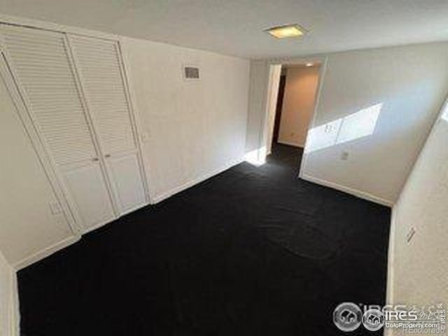 709 S 2nd Ave S, Sterling, CO 80751 - unfurnished bedroom with dark colored carpet and baseboards