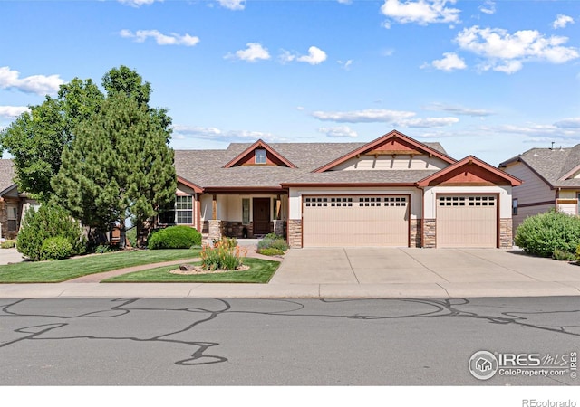 1787 Gore Creek Ct, Windsor, CO 80550 - craftsman house featuring stone siding, an attached garage, concrete driveway, stucco siding, and roof with shingles
