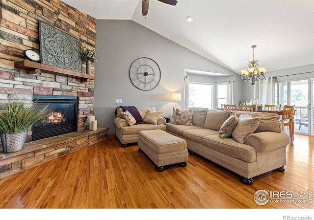 1787 Gore Creek Ct, Windsor, CO 80550 - living room featuring wood finished floors, a chandelier, a ceiling fan, a fireplace, and high vaulted ceiling