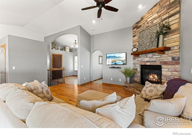 1787 Gore Creek Ct, Windsor, CO 80550 - living area featuring arched walkways, wood finished floors, a ceiling fan, a fireplace, and high vaulted ceiling