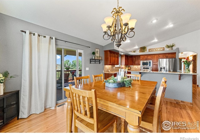 1787 Gore Creek Ct, Windsor, CO 80550 - dining room featuring light wood finished floors, vaulted ceiling, and a chandelier