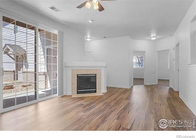 5151 29th St W Unit 204, Greeley, CO 80634 - unfurnished living room featuring wood finished floors, a ceiling fan, and a fireplace