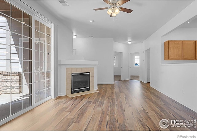 5151 29th St W Unit 204, Greeley, CO 80634 - unfurnished living room with ceiling fan, wood finished floors, and a tiled fireplace