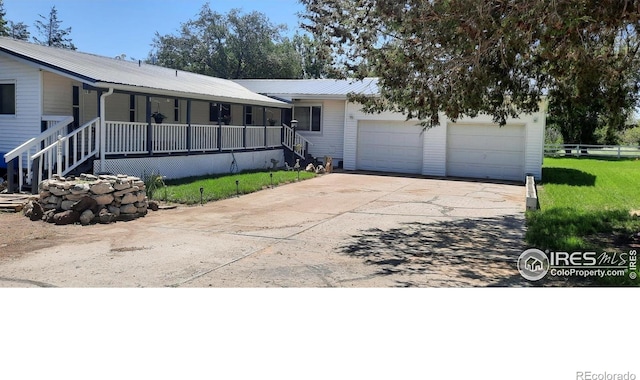 15296 County Road 39, Sterling, CO 80751 - view of front of property with a porch, a metal roof, driveway, and a garage