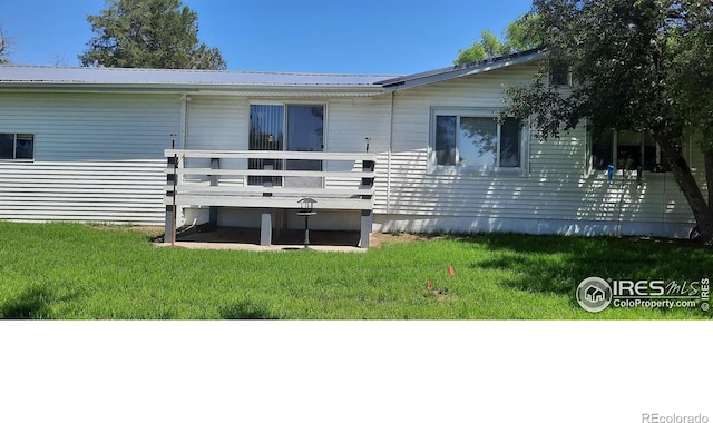 15296 County Road 39, Sterling, CO 80751 - back of house with a yard, a metal roof, and a wooden deck