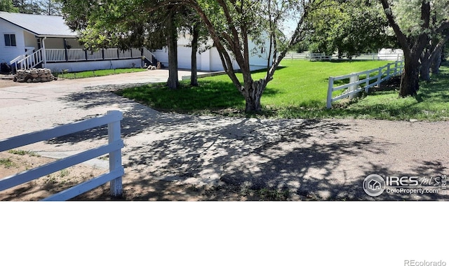 15296 County Road 39, Sterling, CO 80751 - view of yard with driveway, a porch, and a garage