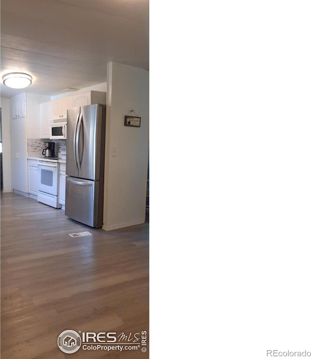 15296 County Road 39, Sterling, CO 80751 - kitchen with white appliances, white cabinetry, wood finished floors, tasteful backsplash, and light countertops