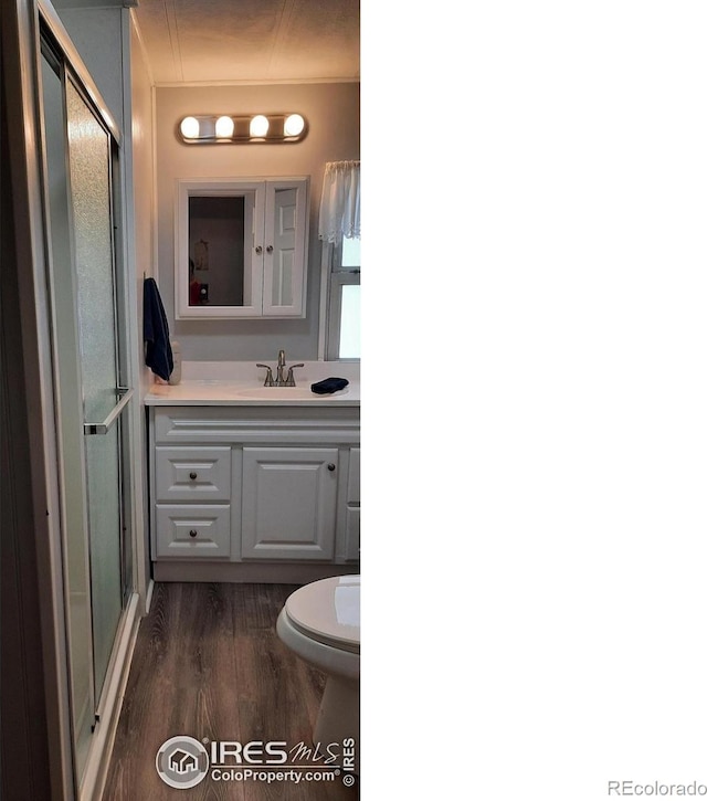 15296 County Road 39, Sterling, CO 80751 - bathroom featuring vanity, wood finished floors, and a shower with door
