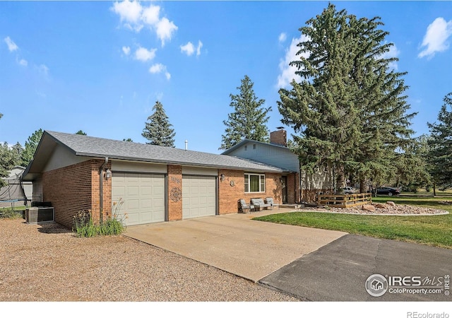 108 40th Ave, Greeley, CO 80634 - view of front of house featuring a garage, brick siding, concrete driveway, a front lawn, and a chimney