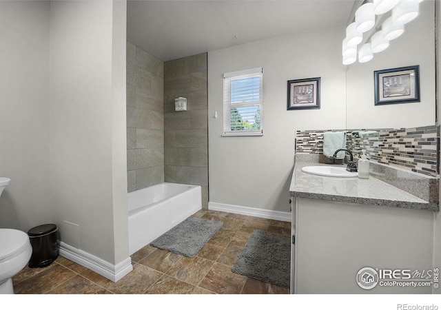 108 40th Ave, Greeley, CO 80634 - bathroom featuring vanity, decorative backsplash, and tub / shower combination
