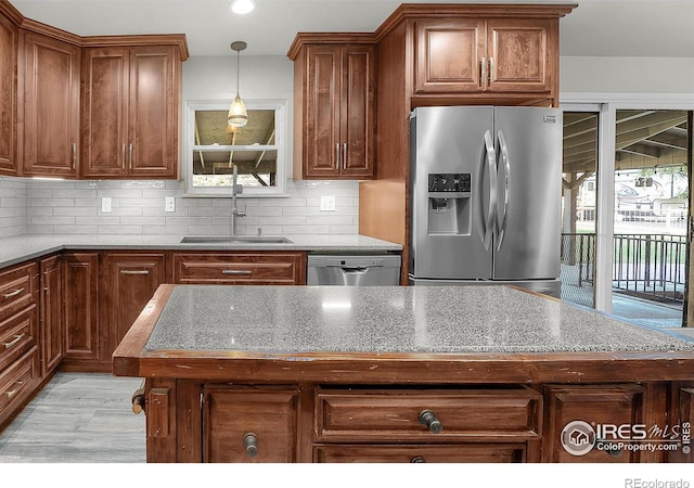 108 40th Ave, Greeley, CO 80634 - kitchen featuring stainless steel appliances, tasteful backsplash, pendant lighting, brown cabinets, and recessed lighting
