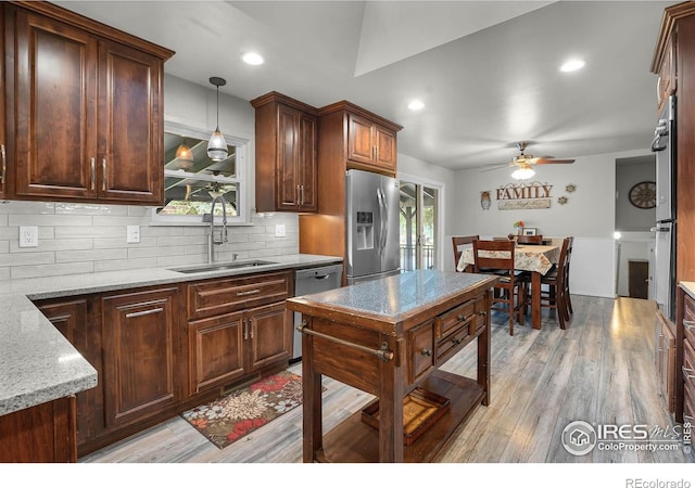 108 40th Ave, Greeley, CO 80634 - kitchen featuring stainless steel appliances, a ceiling fan, backsplash, pendant lighting, and light wood-style floors