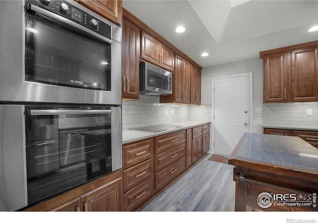 108 40th Ave, Greeley, CO 80634 - kitchen featuring stainless steel appliances, light wood-type flooring, backsplash, recessed lighting, and light stone counters