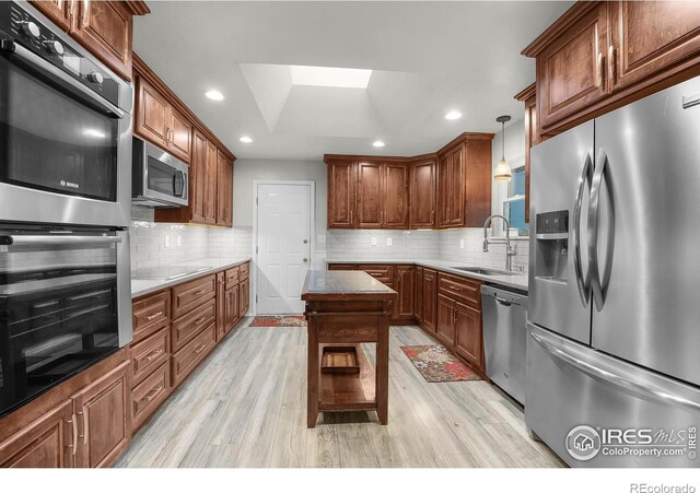108 40th Ave, Greeley, CO 80634 - kitchen featuring stainless steel appliances, light wood-style floors, decorative backsplash, recessed lighting, and a skylight