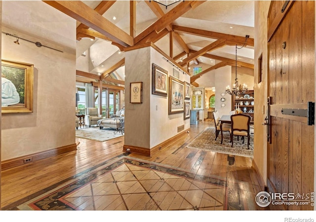 6619 Ridgeline Dr, Timnath, CO 80547 - foyer entrance featuring hardwood / wood-style flooring, beam ceiling, a chandelier, and high vaulted ceiling