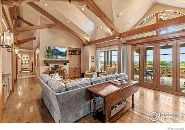6619 Ridgeline Dr, Timnath, CO 80547 - living area featuring light wood-style floors, high vaulted ceiling, french doors, a warm lit fireplace, and recessed lighting