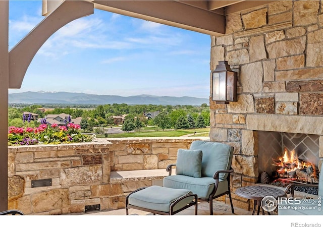 6619 Ridgeline Dr, Timnath, CO 80547 - view of patio featuring an outdoor stone fireplace and a mountain view