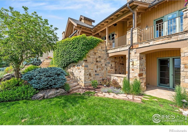 6619 Ridgeline Dr, Timnath, CO 80547 - exterior space with a balcony, stone siding, and a yard